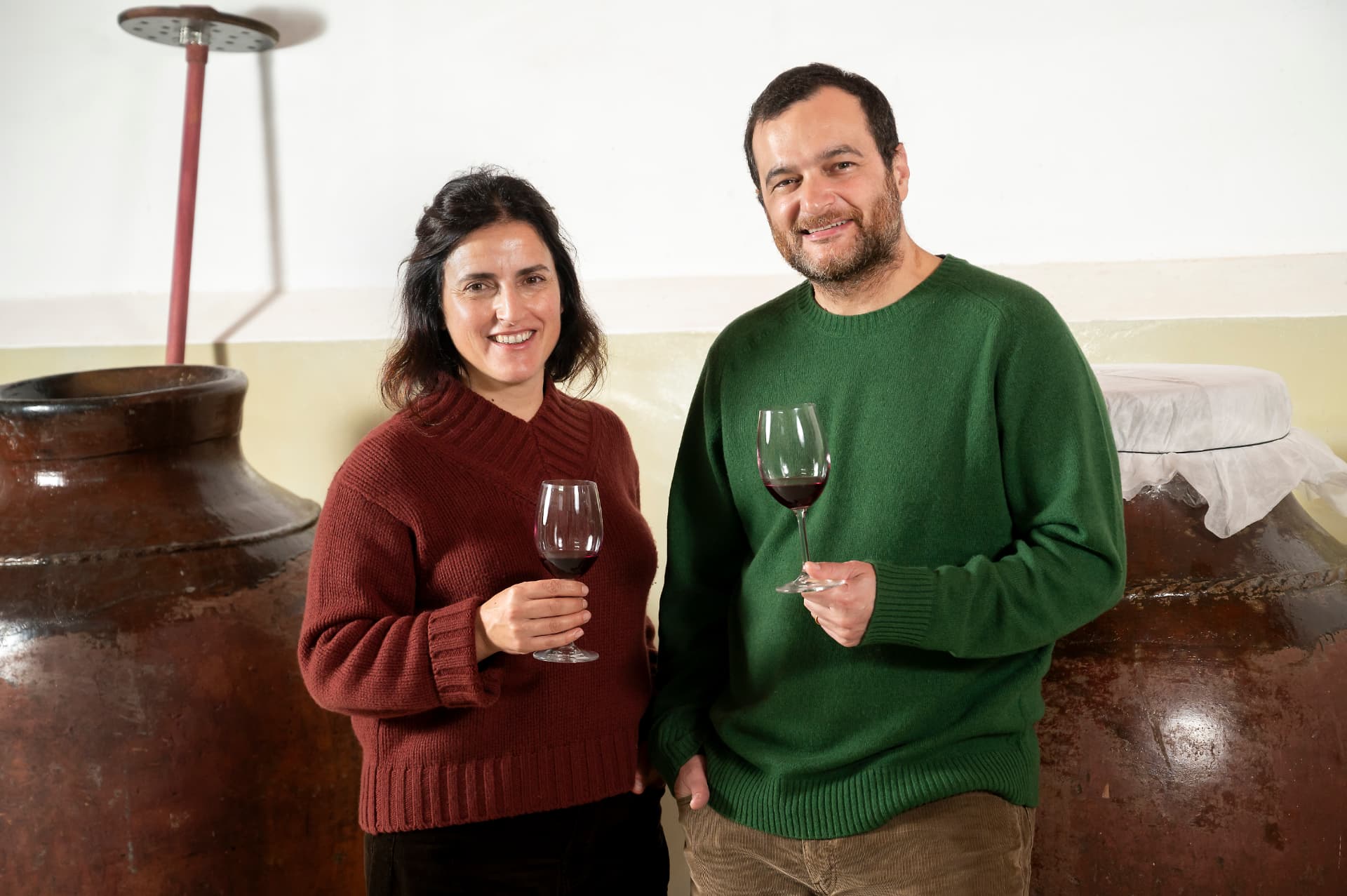 Sandra Alves e Diogo Lopes com uma taça de vinho entre as talhas